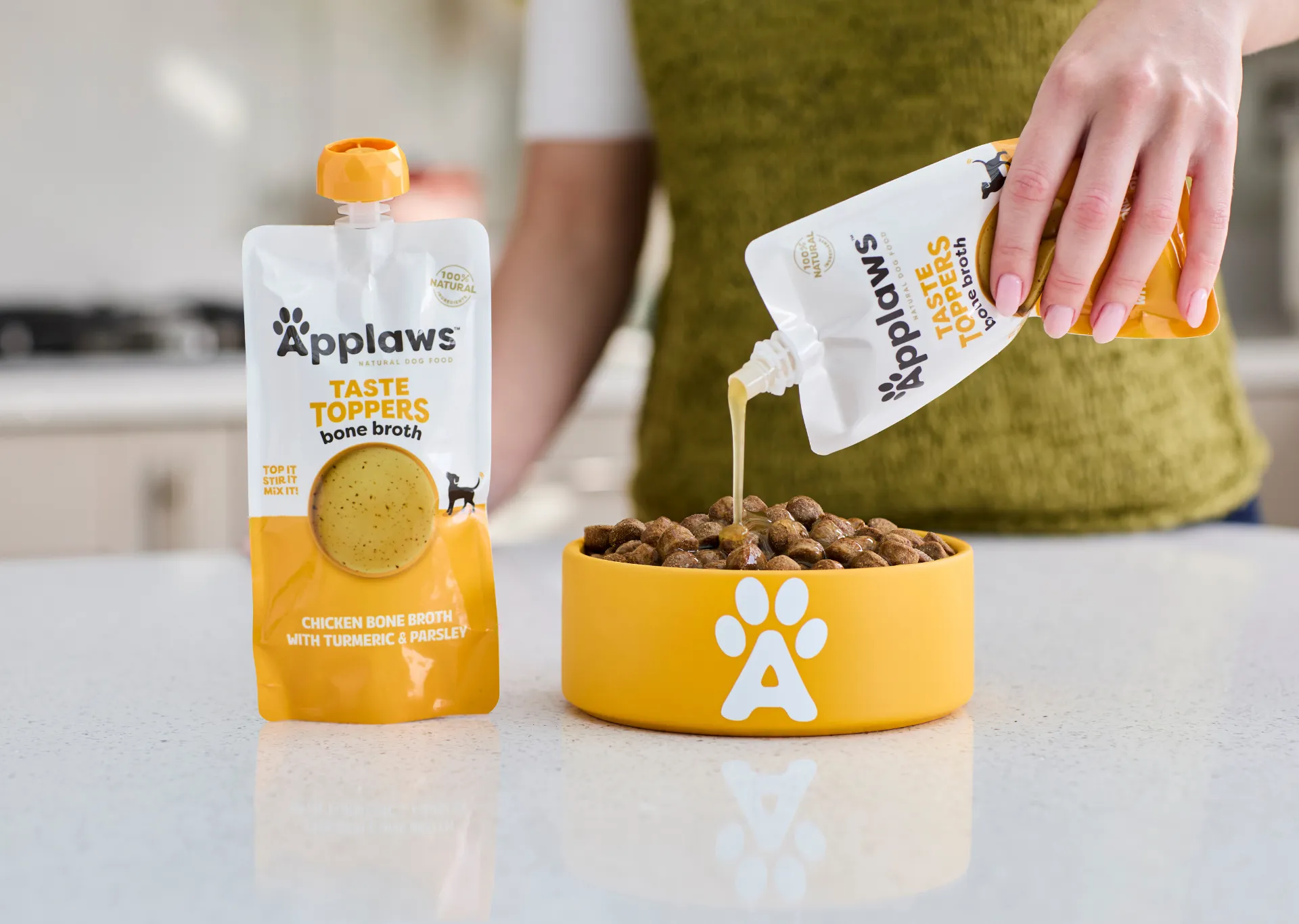 Applaws Chicken bone broth being pourced onto Applaws Dry Dog food